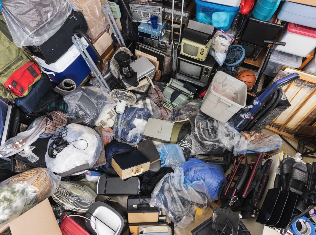 Overhead view of packed storage with electronics, bins, fans, and household items for Pontiac cleanup