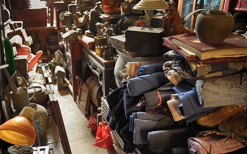 Packed room with antiques, clothing, books, and furniture before a Pontiac estate cleanout